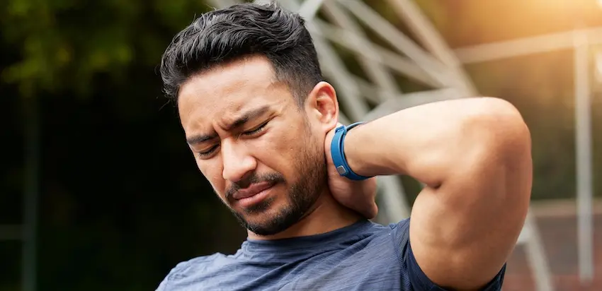 A male accident victim is holding his neck while being in pain and is experiencing delayed injuries and whiplash symptoms after a motor vehicle accident in Atlanta.