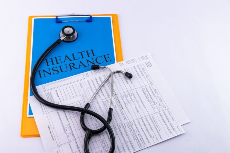 A clipboard with health insurance documents and medical forms alongside a stethoscope for policy review and claims at Atlanta Accident Lawyers.