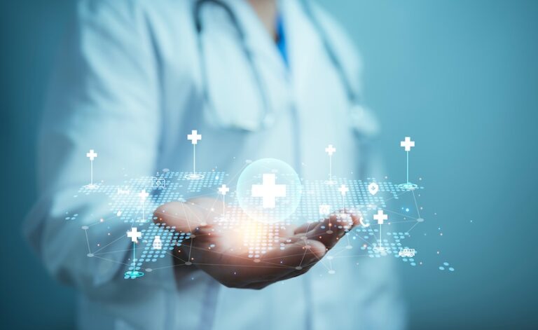 A doctor in a white coat and stethoscope holds out an open palm displaying a glowing digital medical cross surrounded by a network of healthcare icons and a dotted world map illustrating the advanced care and future medical treatments that serious accident injury victims may need as part of their long-term recovery in Metro Atlanta.