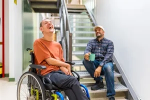 A disabled person laughing with a friend, highlighting the importance of legal help in a permanent disability claim. Experienced attorneys can secure disability benefits and financial support for those unable to work due to permanent impairment.