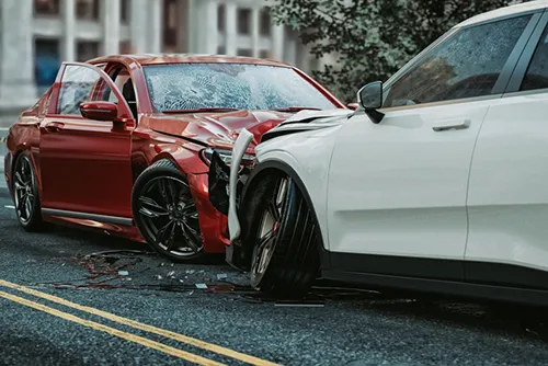 Head on collision between red and white sedans
