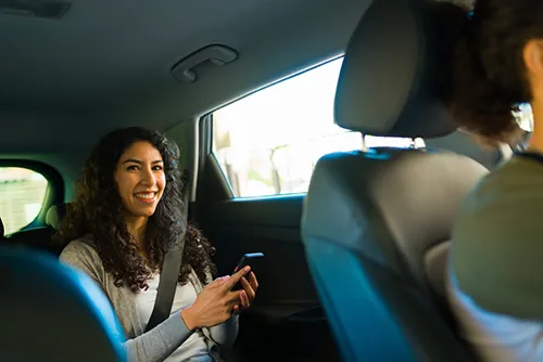 Woman on her phone in the back of an Uber